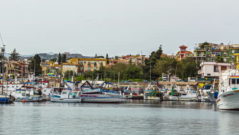 Timelapse-of-the-wonderful-italian-harbor-with-boats-and-ships-in-sicily,-italy-during-calm-sea-and-view-of-the-historical-buildings-in-the-background