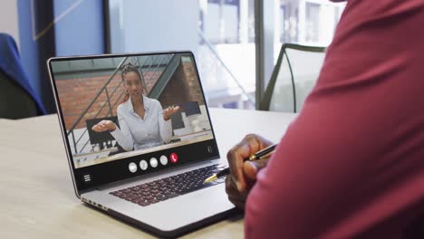 Hombre-Afroamericano-Usando-Una-Computadora-Portátil-Para-Videollamadas,-Con-Un-Colega-De-Negocios-En-La-Pantalla