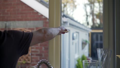 Male-hand-closing-kitchen-window