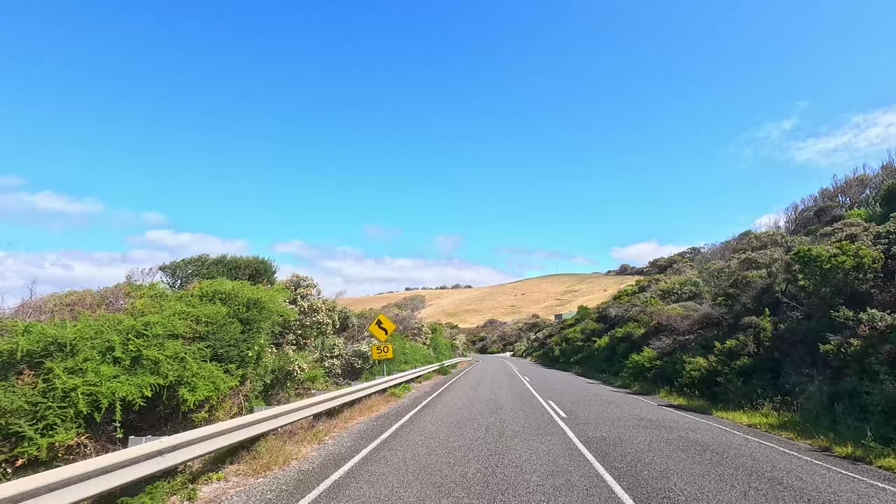 A 14-second video capturing a drive along the Great Ocean Road, showcasing winding roads, lush greenery, and clear blue skies