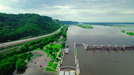aerial view of mississippi river lock and dam with highway and lush green landscape