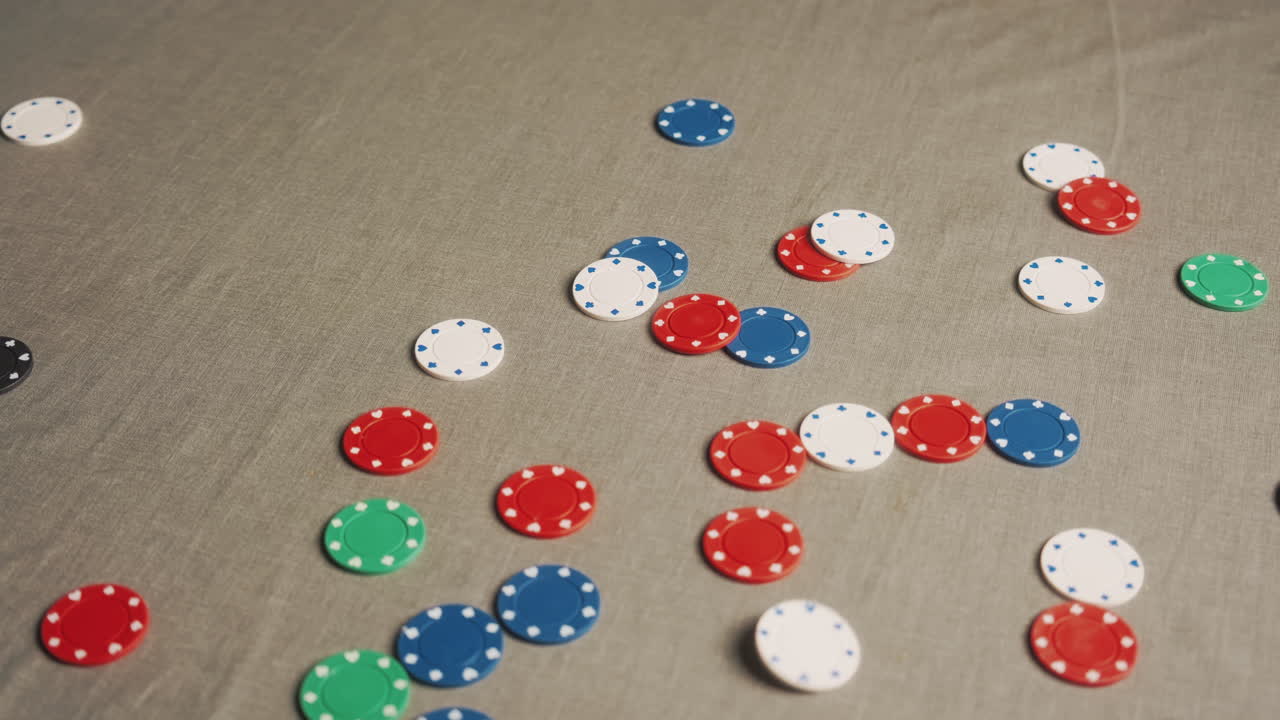 Fiches da poker colorate che cadono su un tavolo grigio, inquadratura media, statica