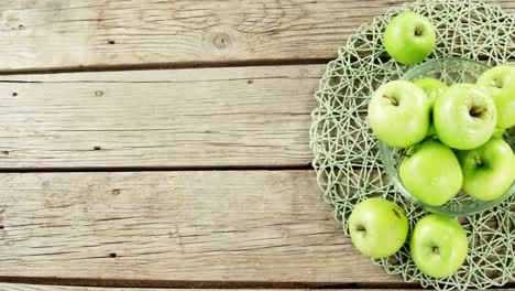 green apples and knife on wooden plank