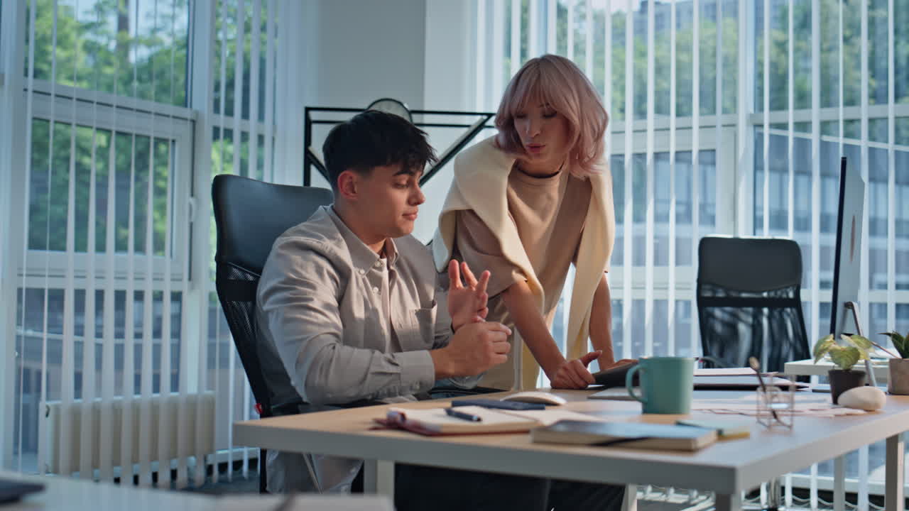 Office couple pointing tablet discussing buro agency closeup. Colleagues working