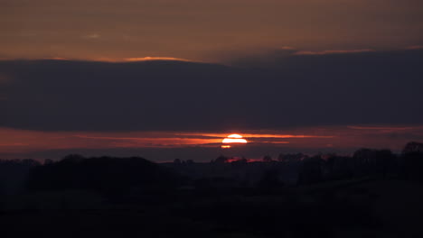 time lapse of a beautiful winter sunset over hillside farmland at nether heage in derbyshire