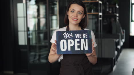 woman holding open sign