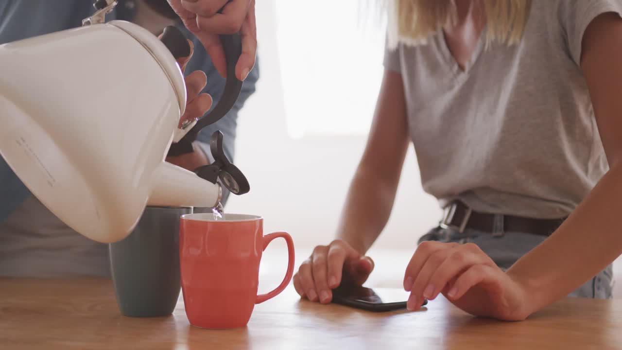 중간 섹션 남자가 테이블 위에 커피 컵에 물을  ⁇ 고 있습니다.