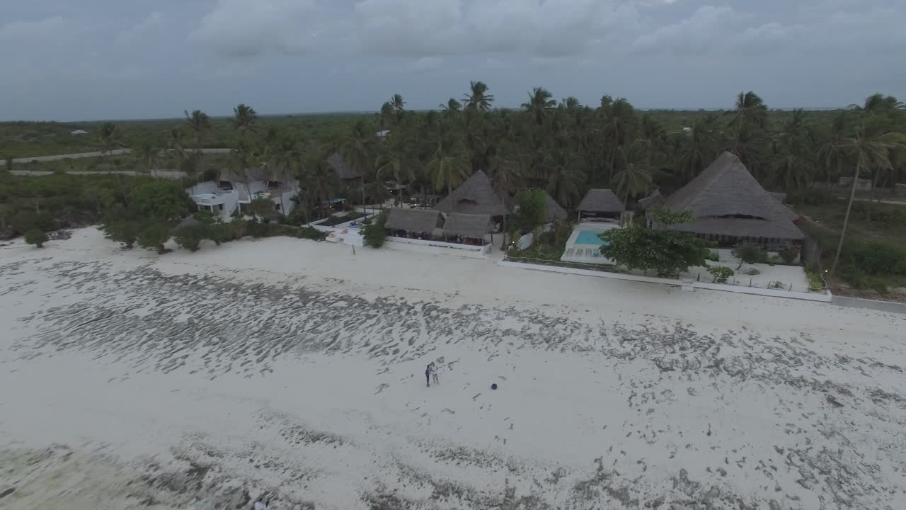 Drone shot of a White beach and The Rock during low tide in Zanzibar, Tanzania