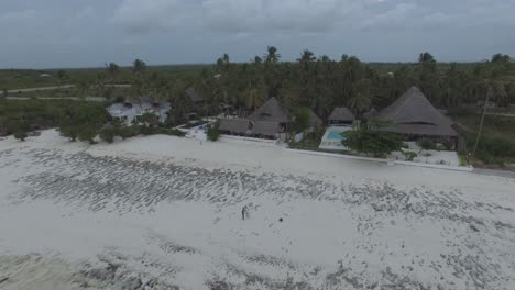drone shot of a white beach and the rock during low tide in zanzibar, tanzania