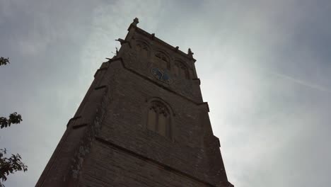 Walking-towards-tall-church-bell-tower-against-grey-sky