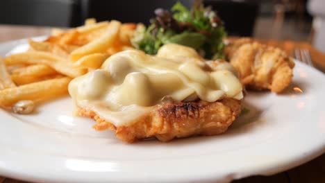 delicious chicken parmesan with fries and salad