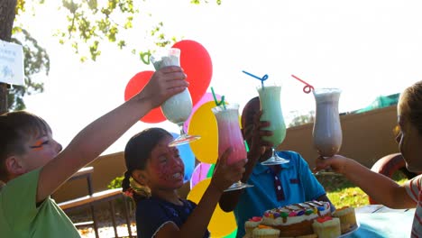 niños brindando vasos de bebidas en el patio de recreo 4k