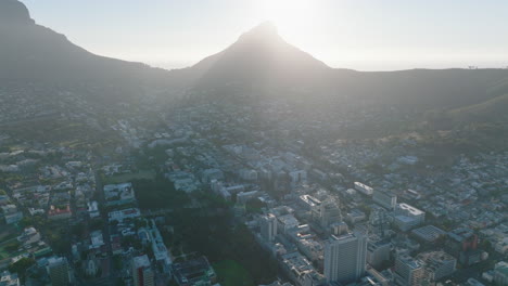 Against-sun-view-of-town-development-in-slope-under-Lions-Head-mountain.-Bright-light-limiting-visibility.-Cape-Town,-South-Africa