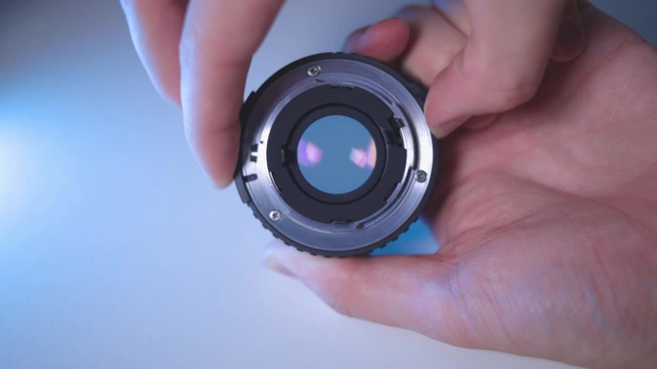 카메라 렌즈의 조리개를 닫고 여는 손 - 클로즈업