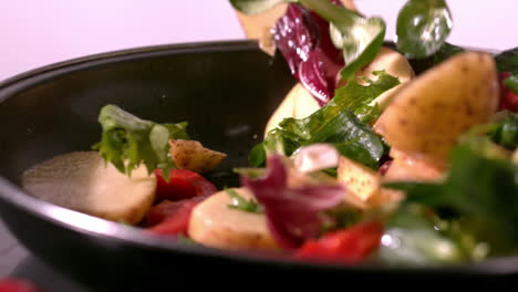 potato and salad falling in a pan