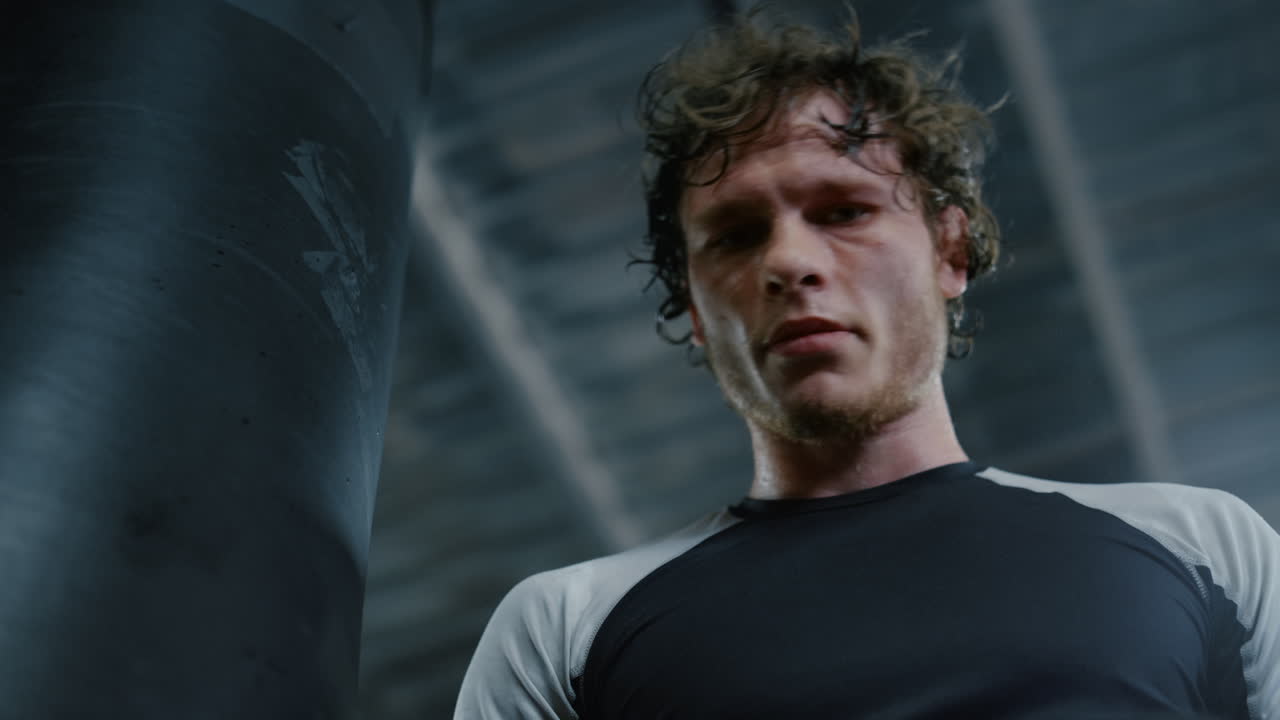 피트니스 센터에서 렌즈를 쳐다보는 매력적인 전투기