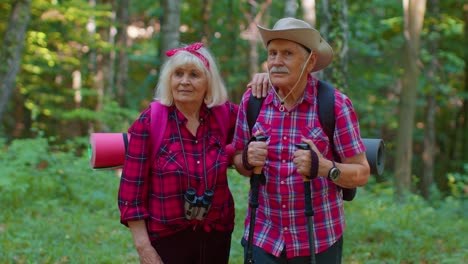 abuela anciana abuelo turistas disfrutando de caminar, hacer senderismo con mochilas en el bosque de verano