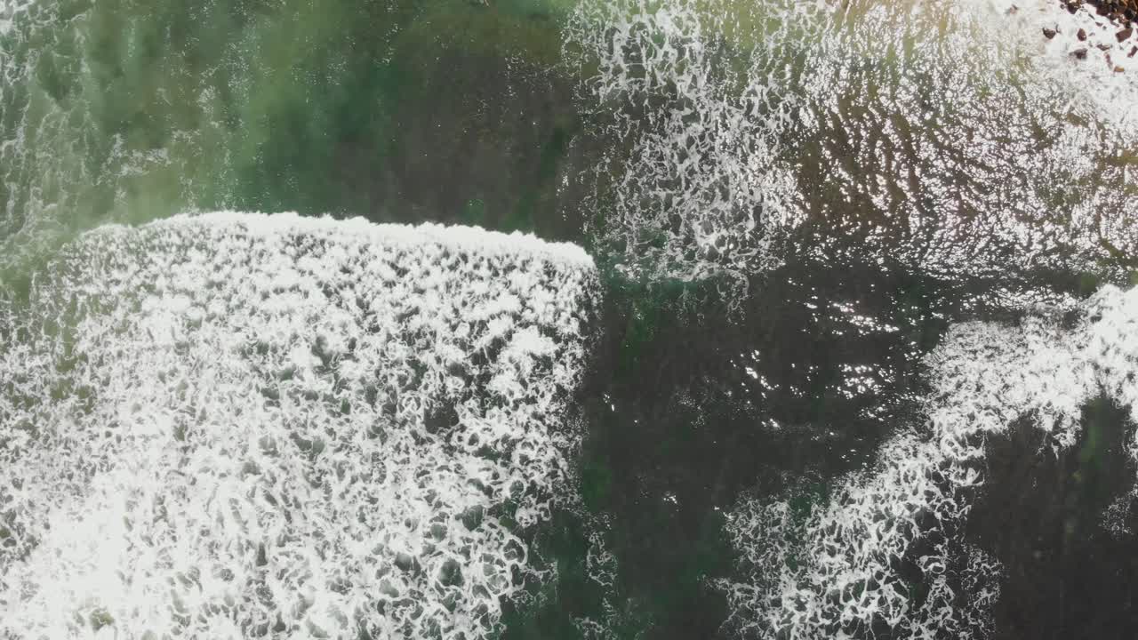 Aerial View of Ocean Waves Crashing on Rocky Shore