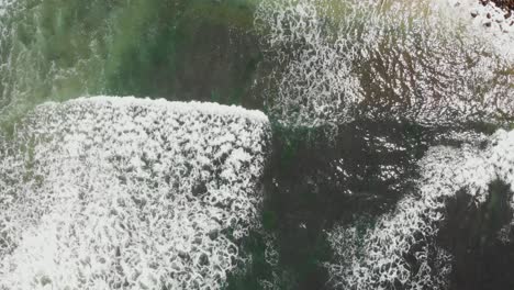aerial view of ocean waves crashing on rocky shore