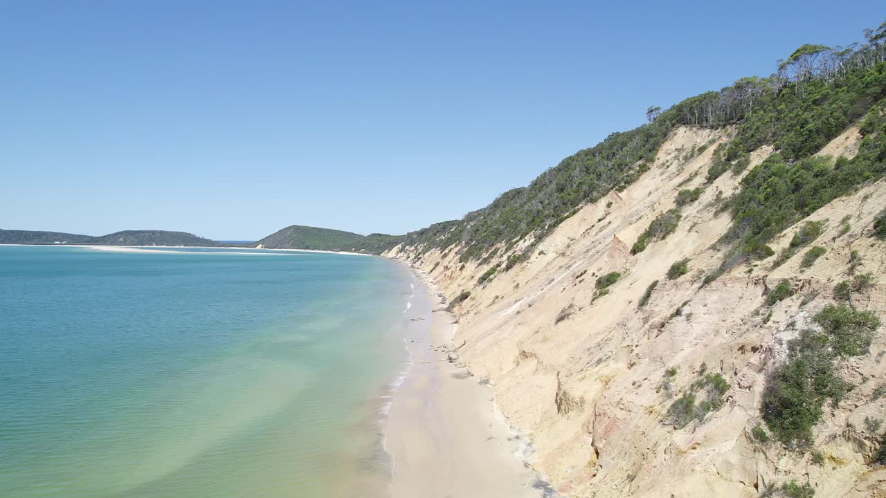 vista aérea de la playa del arco iris con vibrantes acantilados de arena, playa de arena blanca y mar azul tranquilo en cooloola, queensland