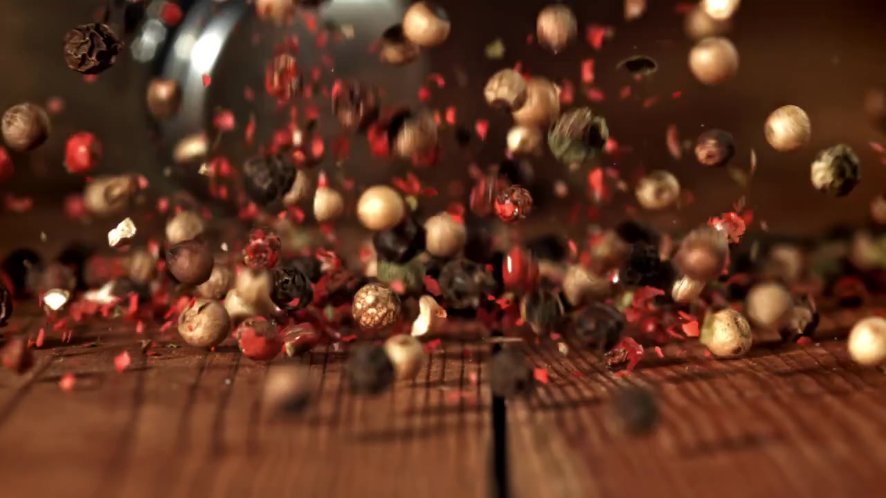 Mixed Peppercorns Falling in Slow Motion onto a Rustic Wooden Table