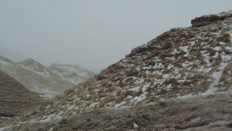 Slow-motion-snow-fall-at-start-of-snow-storm-in-valley-of-hills-during-winter