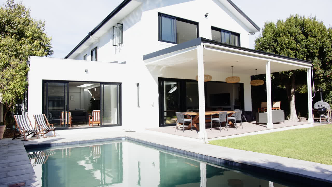 Modern house with swimming pool and outdoor dining area in backyard