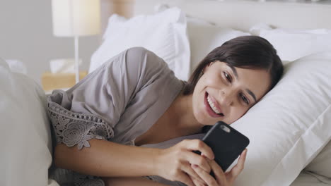 A-young-woman-using-her-phone-while-lying