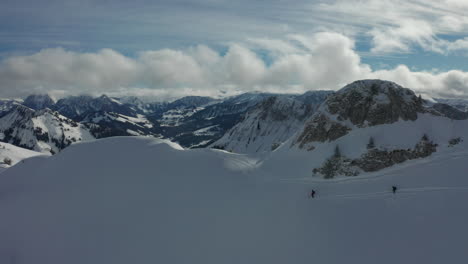 Antenne-Zu-Zwei-Skifahrern-Auf-Schneebedeckter-Piste-Mit-Einer-Wunderschönen-Berglandschaft-Im-Hintergrund