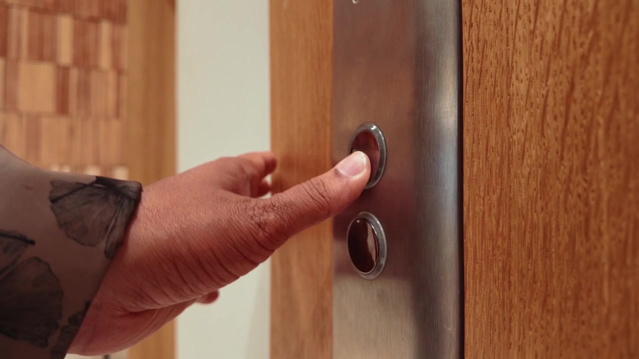 Person Pressing Elevator Button in Modern Building