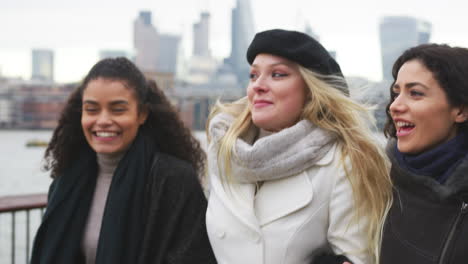 amigas caminan por la orilla sur en una visita de invierno a londres.