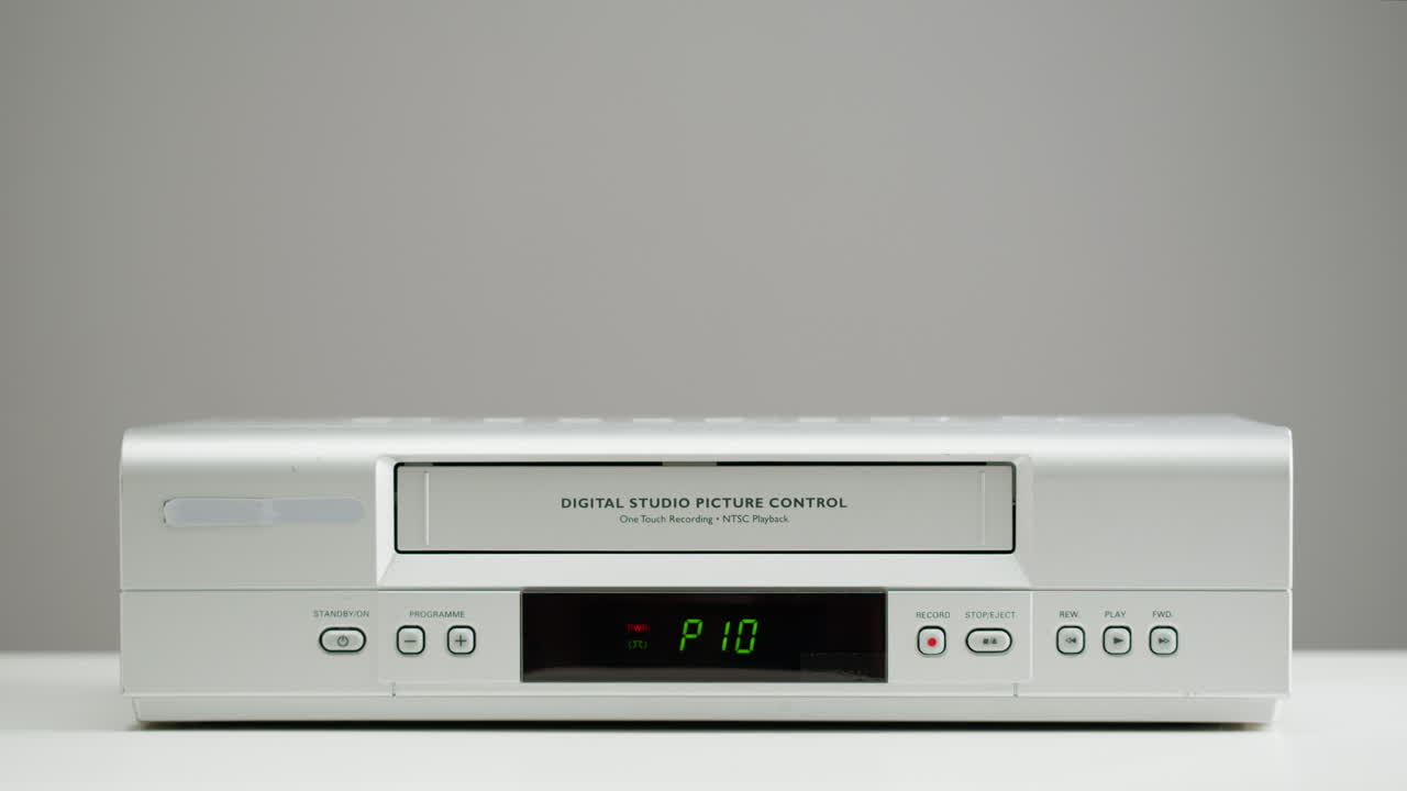 Mano che inserisce una cassetta in un videoregistratore vintage
