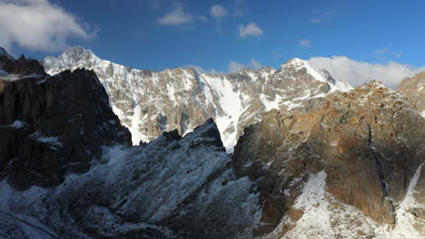 cinematic epic drone shot of a steep mountain top in the ak-sai glacier in kyrgyzstan