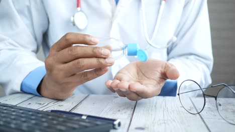médico que aplica desinfectante para las manos