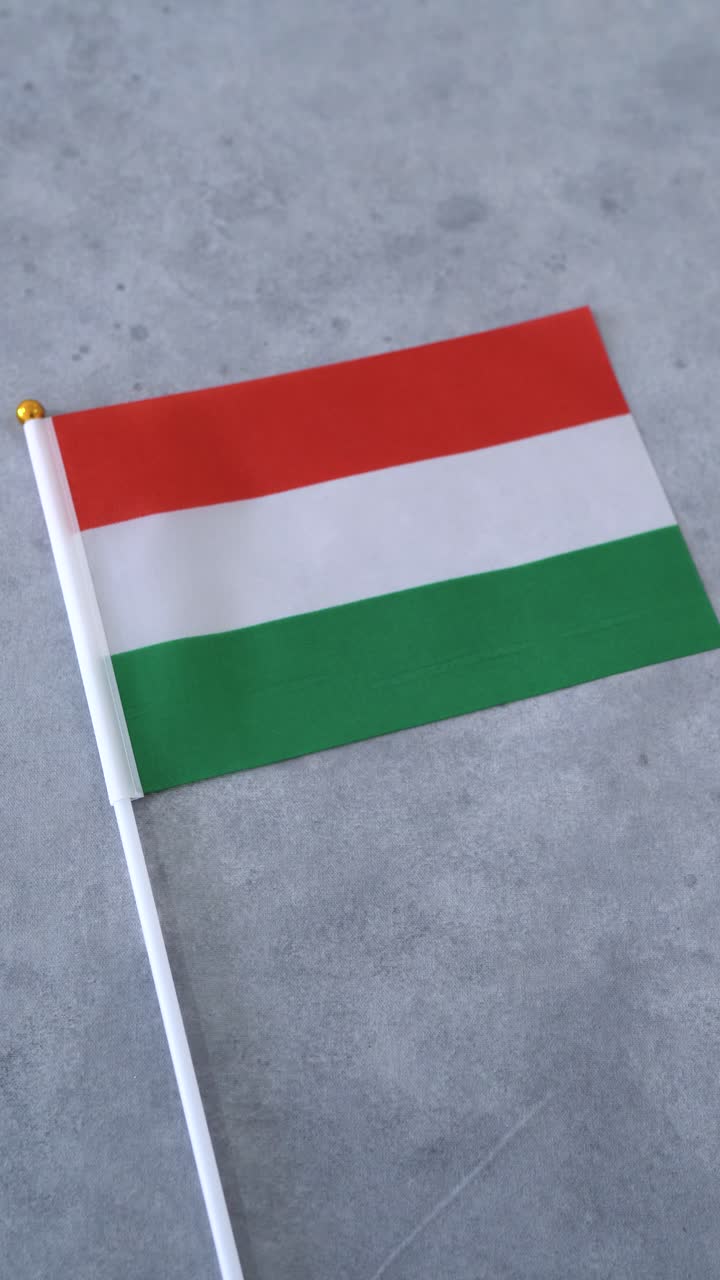 Bandiera dell'Ungheria, scatto ravvicinato verticale su sfondo grigio. Bandiera nazionale ungherese
