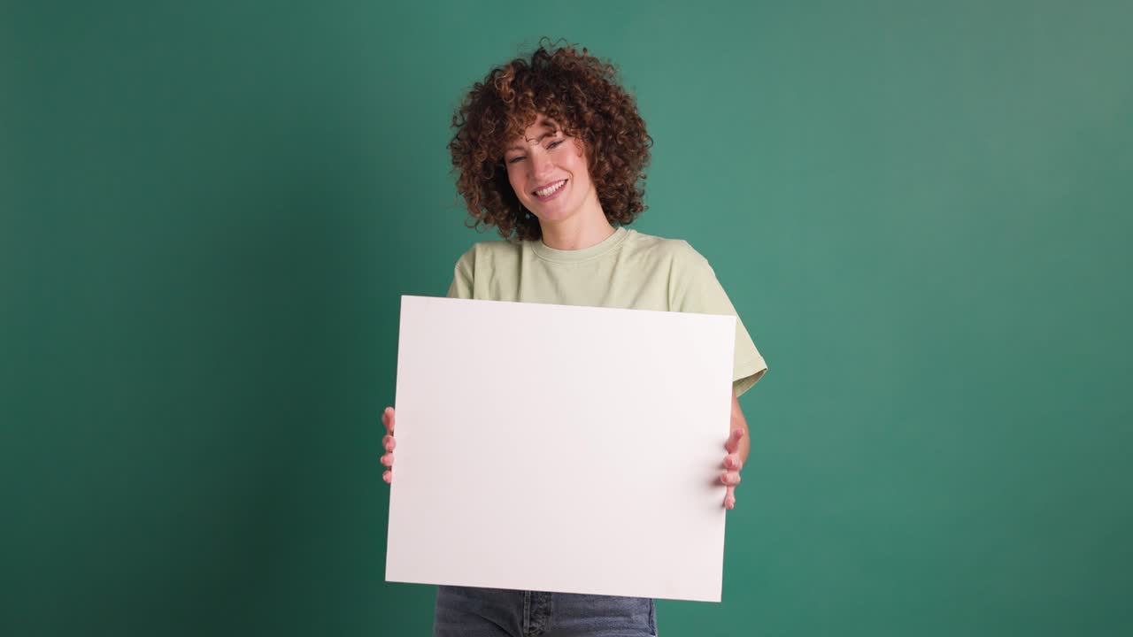 Happy woman holding blank paper in green background