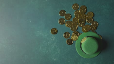 foto de estudio superior de sombrero de copa de duende verde y montones de monedas de oro para celebrar el día de san patricio 1
