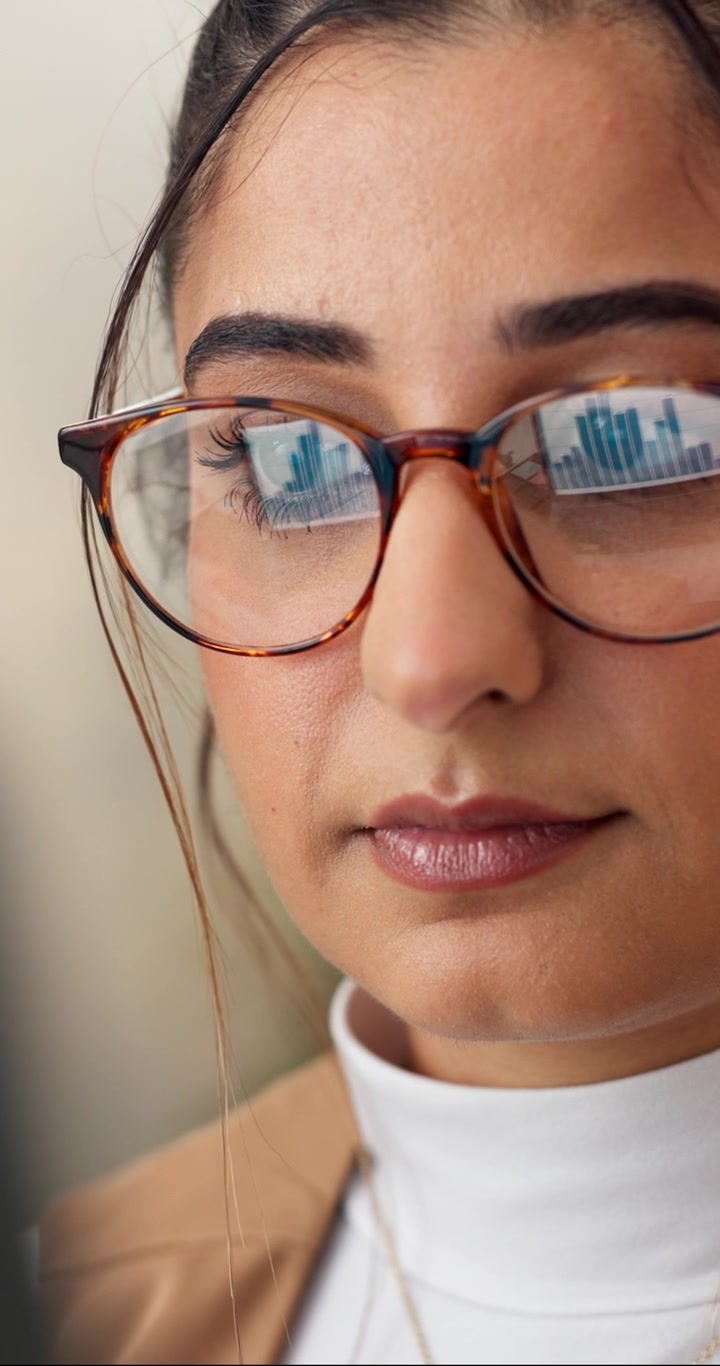 Primo piano di una donna d'affari che osserva grafici finanziari sullo schermo