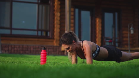 chica en forma haciendo ejercicio de tabla al aire libre en el parque día de verano cálido. concepto de resistencia y motivación