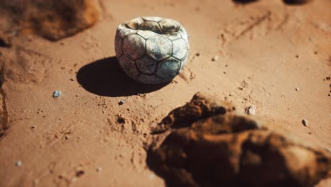 vieja pelota de fútbol en la playa de arena