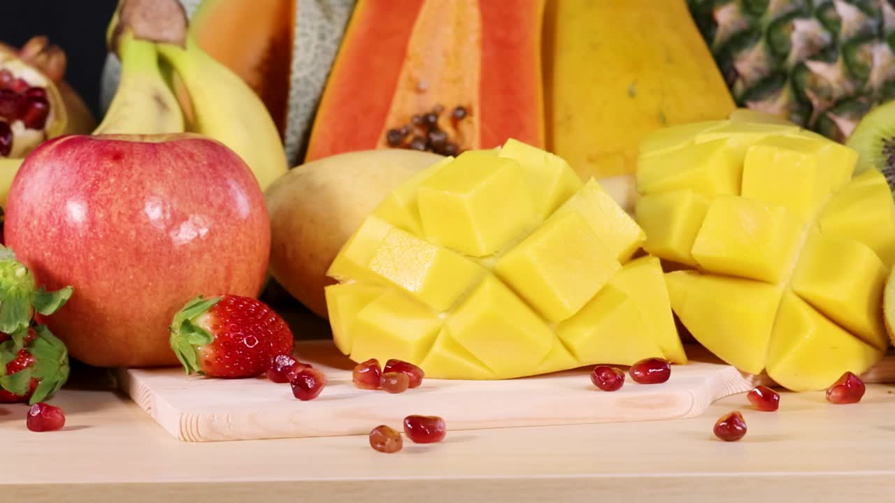 Un primo piano colorato di frutta tropicale fresca, tra cui mango, papaya, ananas e mela a fette