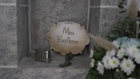 close up of baptism sign and altar flowers in soft light