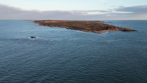 a fly over of mira bay from scatarie island, flying towards a small town over looking the ocean