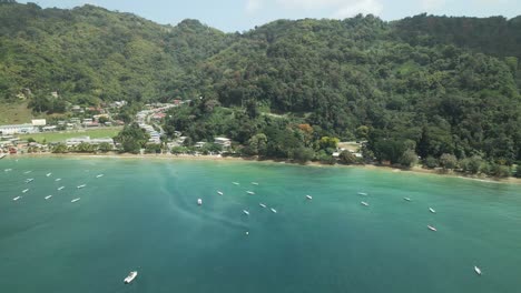 Panorámica-Aérea-A-La-Izquierda-Que-Revela-El-Embarcadero-Y-El-Pueblo-Pesquero-De-Charlotteville,-Tobago