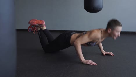 mujer haciendo flexiones en un gimnasio