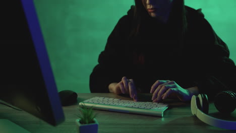 Female-typing-on-the-keyboard-working-with-a-computer-on-a-colorful-background.-Close-up.