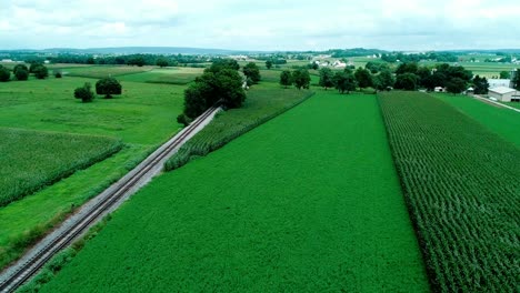 Bahngleise-In-Amischen-Landschaften-Und-Ackerland,-Wie-Von-Drohnen-Gesehen