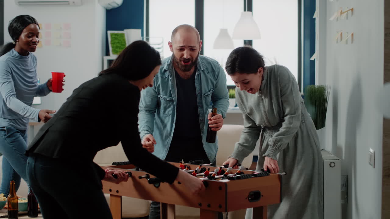 Cheerful woman dancing after winning game at foosball table