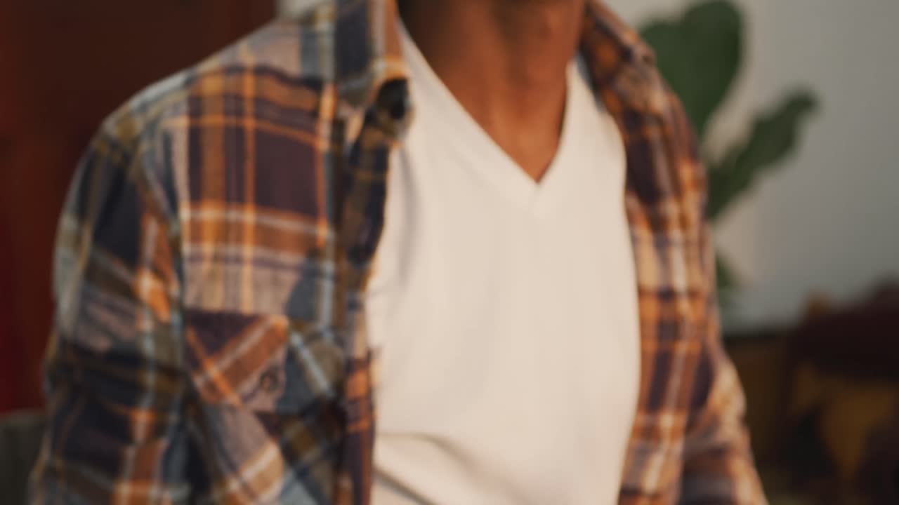 sección media de un artesano afroamericano feliz sosteniendo rollos de cuero en un taller de cuero