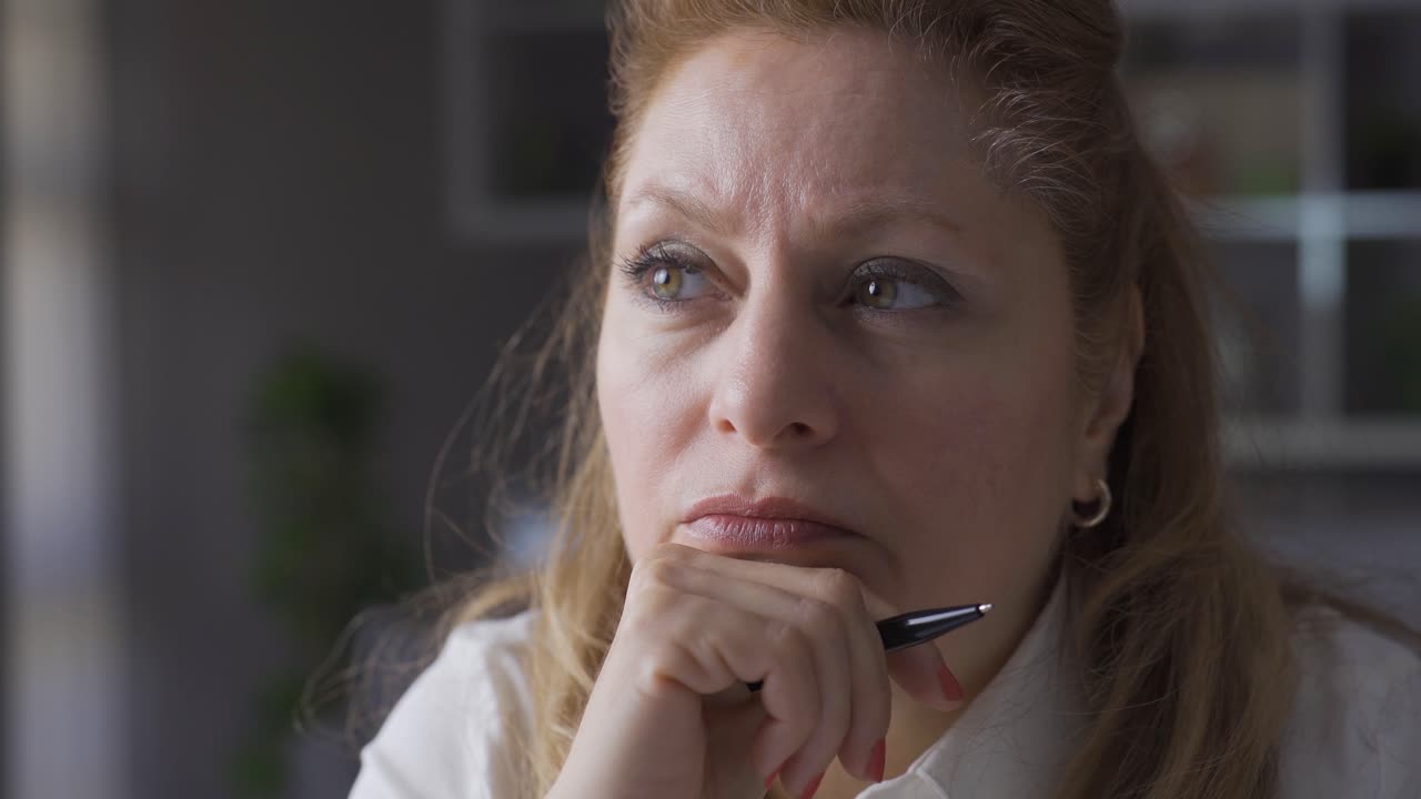 Imprenditrice anziana e concentrata nel suo ufficio domestico prende appunti, elabora piani.